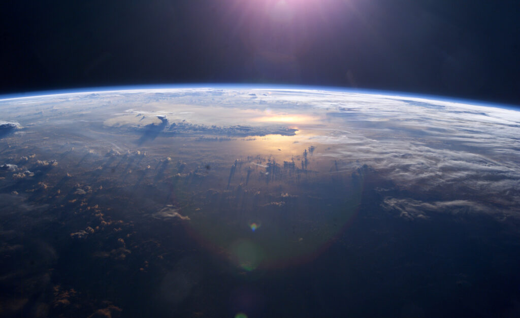 Sunset over the Pacific Ocean as seen from the International Space Station. Tops of thunderclouds are also visible.