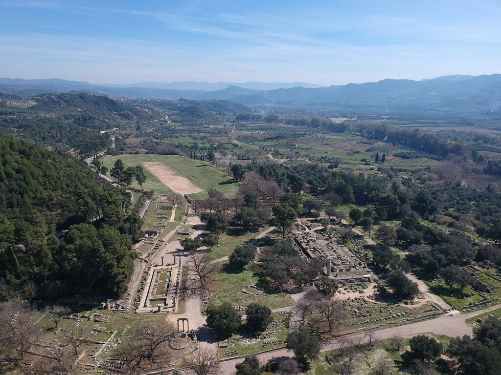 Archaeological site of Olympia showing the stadium, the temple of Hera and the temple of Zeus. The Alfeios valley is visible in the background.