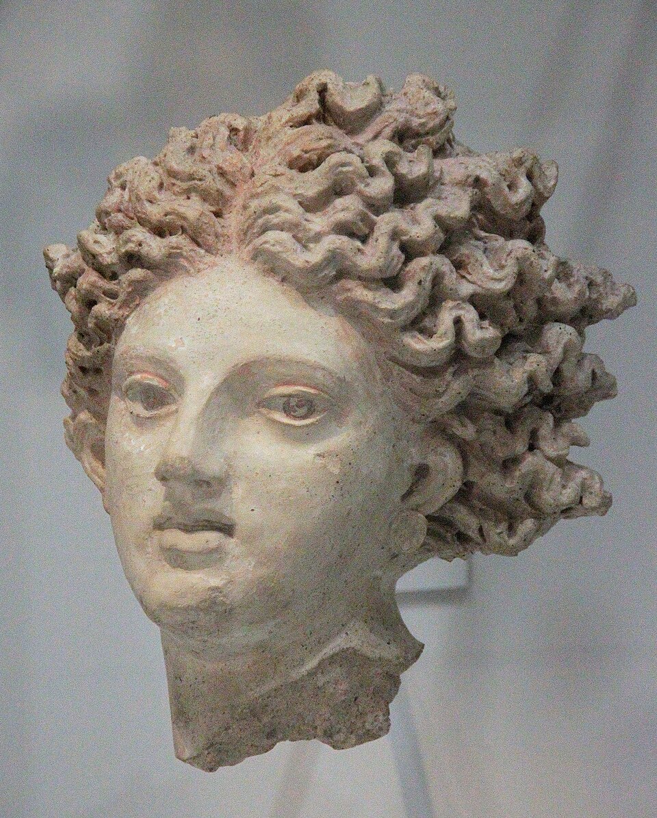 Leucothea, an Etruscan sculpture from Pyrgi, c. 350 BCE. The head only survives; she is looking at the observer with a slightly apprehensive expression. The lips are gently parted; the hair is thick and wavy.